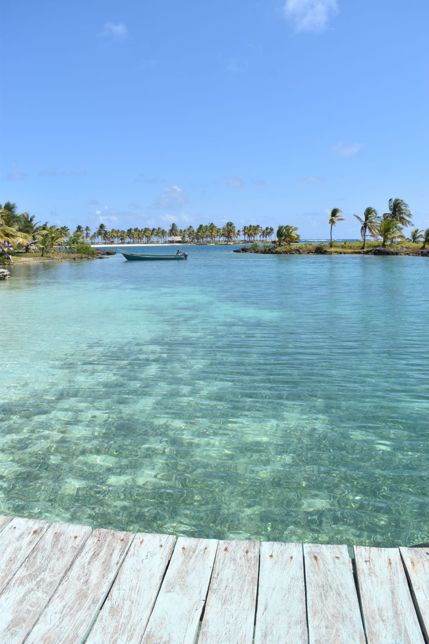 The beautiful San Blas islands with little islands dotted about and a boat in the distance