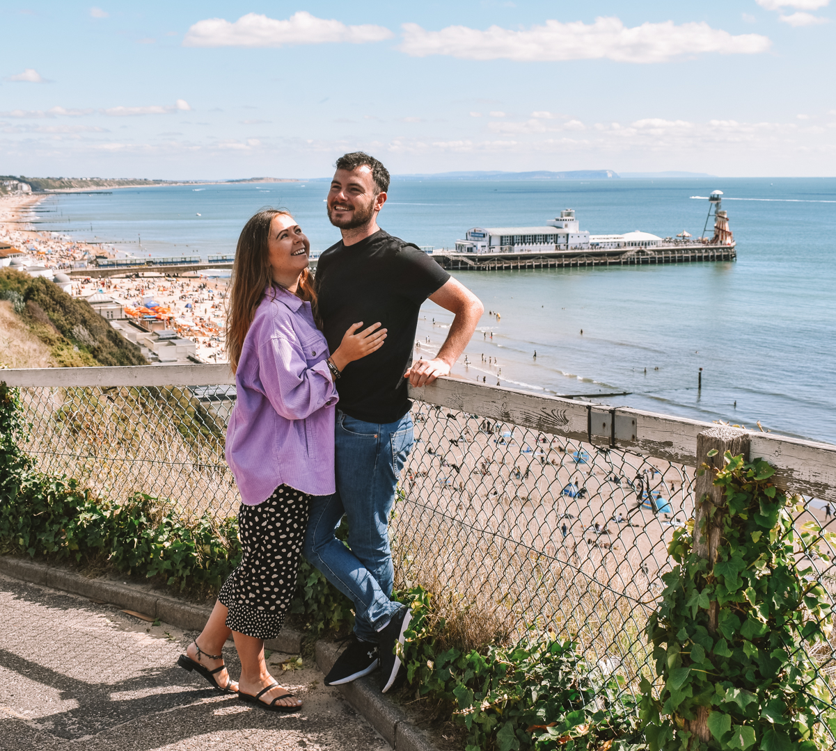 A couple on Bournemouth Beach with Bournemouth Pier in the background