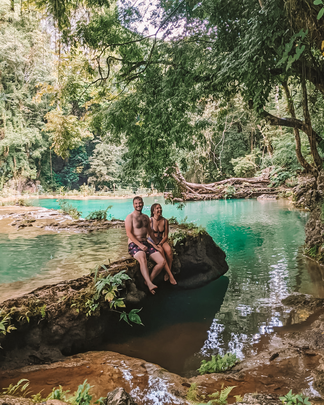 Couple sat on the edge of the pool at Semuc Champey