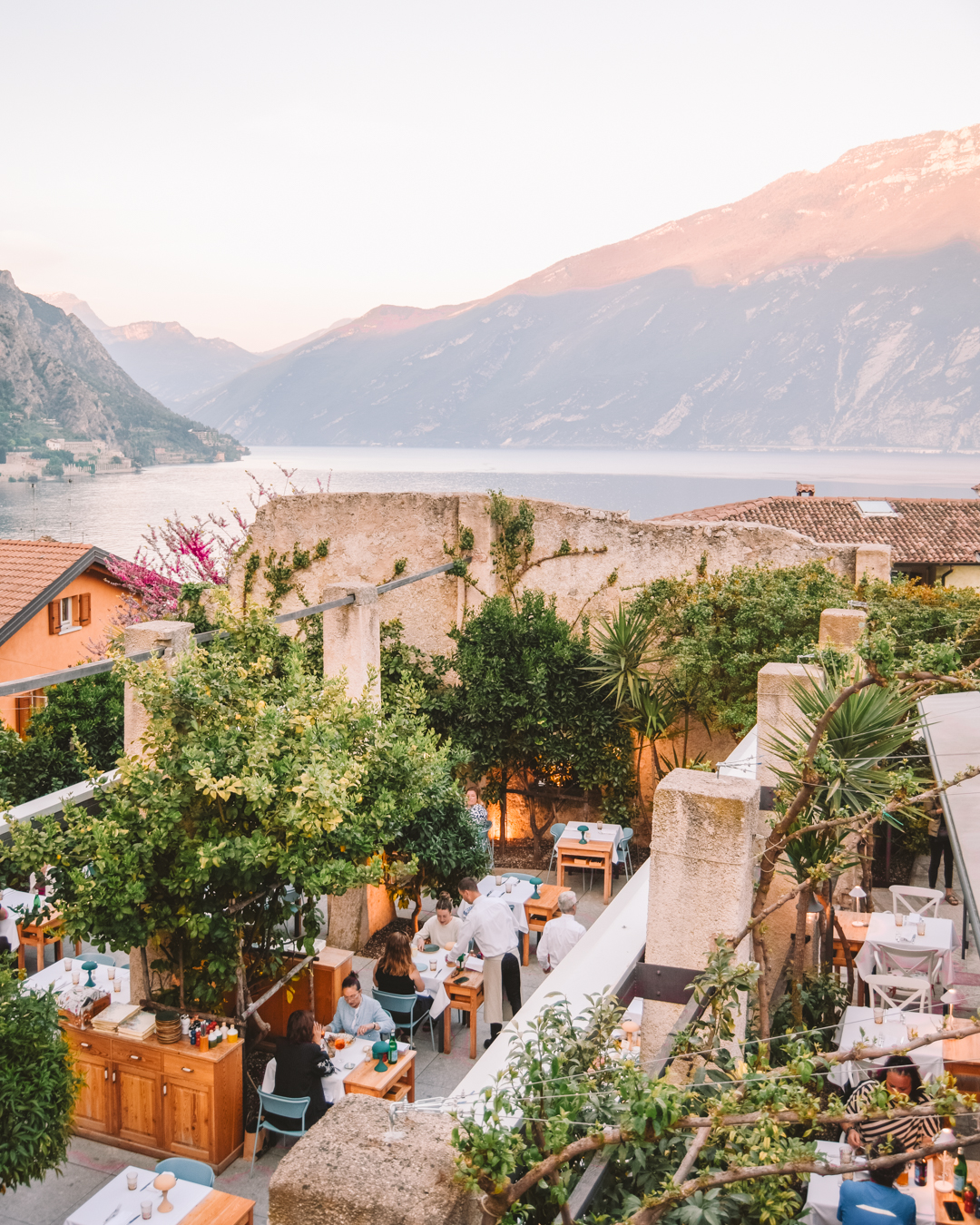 A restaurant in Limone sul Garda with the mountains behind it and an open roof