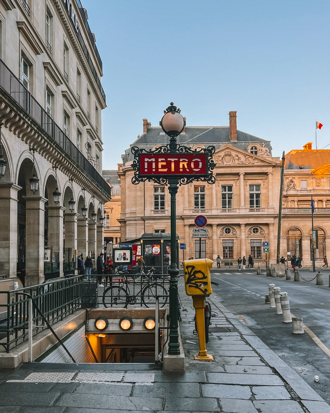 The streets of Paris with a Metro station sign in the shot