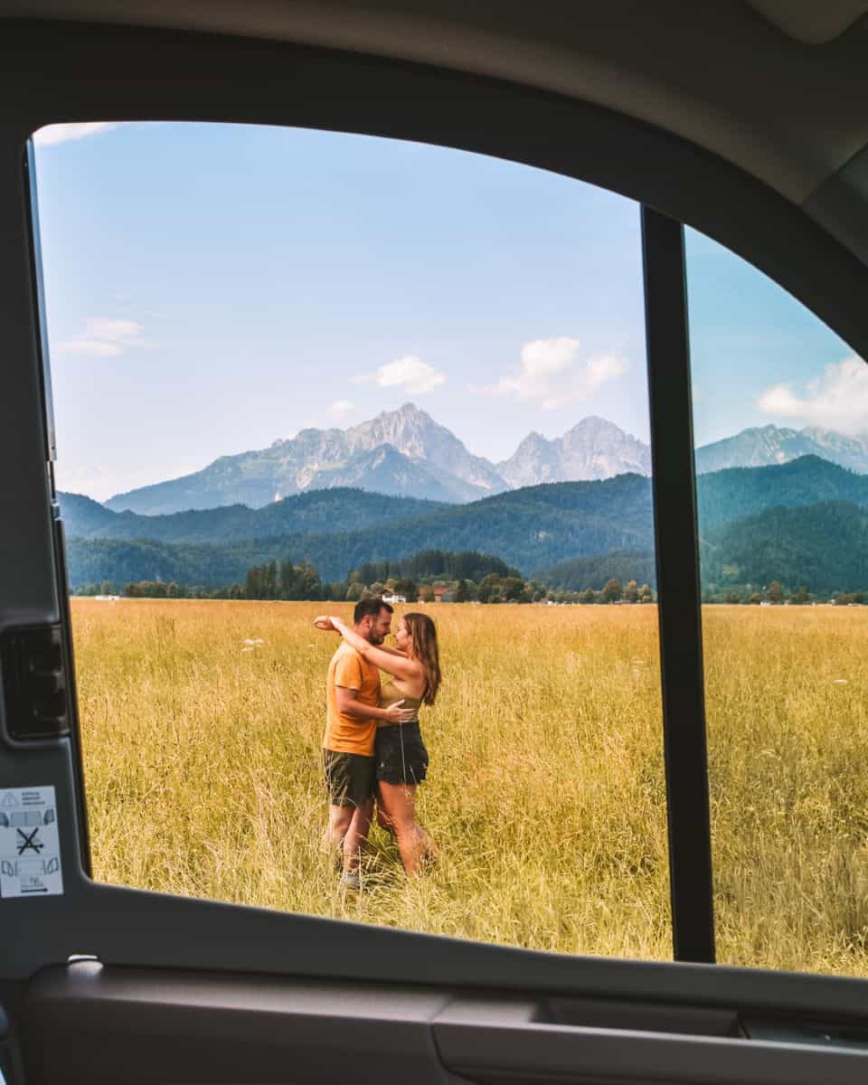 Reanna and Chris through the window of their Roadsurfer campervan in Bavaria Germany