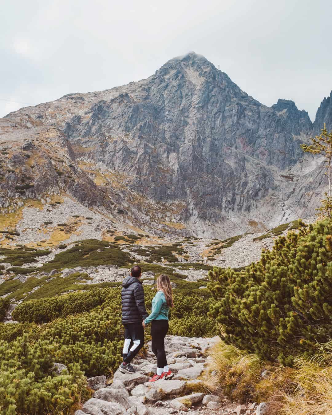 Chris and Reanna stood looking up at a mountain in Tatranská Lomnica