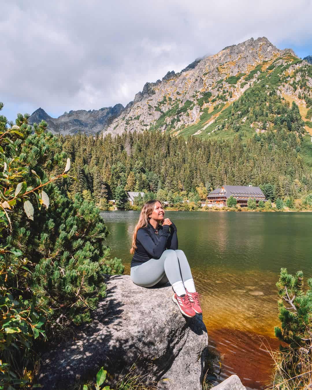 Reanna sat on a rock with a mountain behind and lake