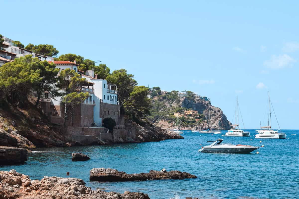 The rocky coast of Mallorca with boats on the sea